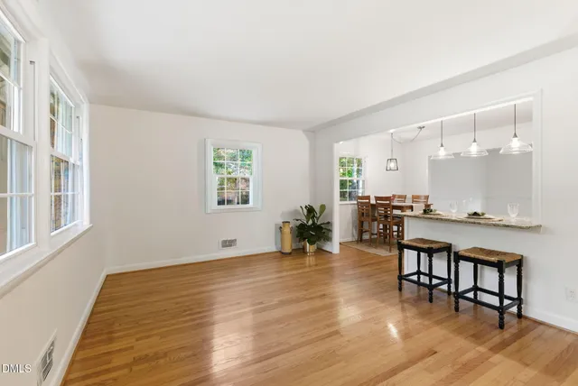 a room with lots of wooden furniture and a dining table with wooden floor