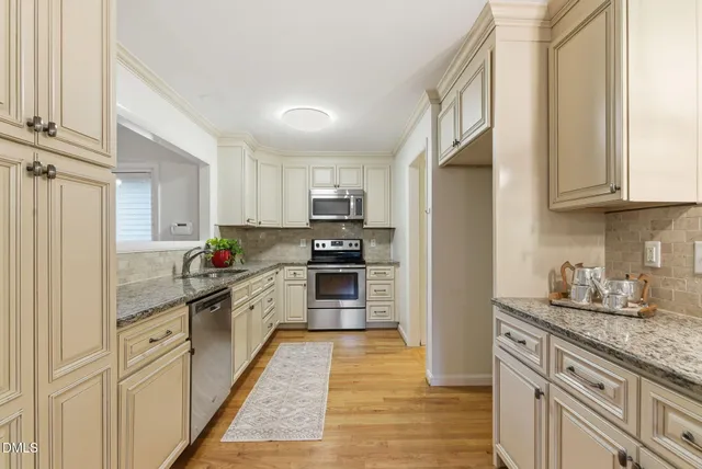 a kitchen with granite countertop a refrigerator stove top oven and sink