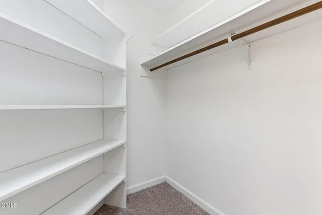 a view of a small house with large tree next to a yard