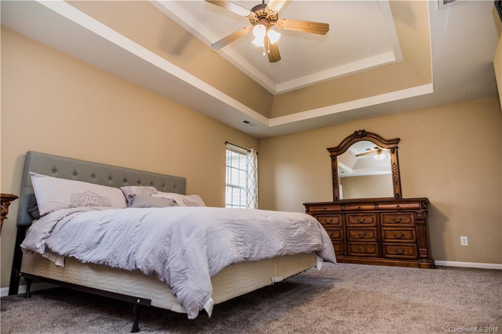 1735 Newland Road Denver, NC 28037 - Photo 12 of 24 a bedroom with a bed and a chandelier