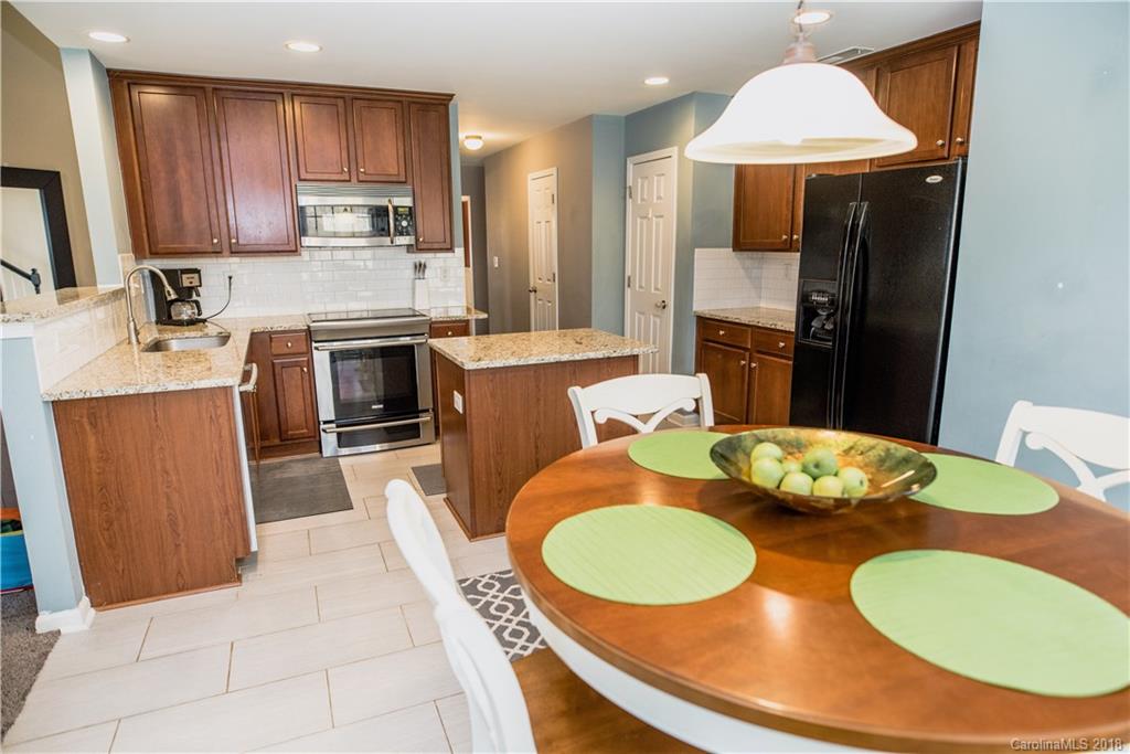 1735 Newland Road Denver, NC 28037 - Photo 8 of 24 a kitchen with stainless steel appliances kitchen island granite countertop a sink a stove a table and chairs
