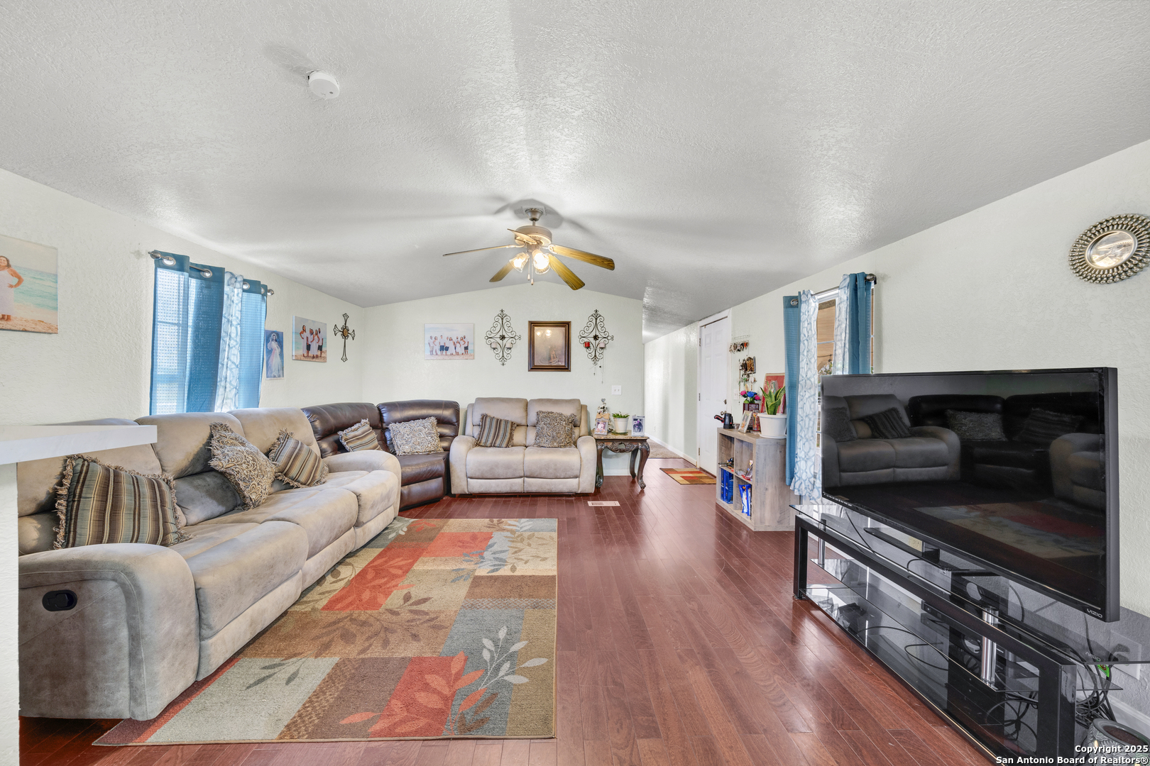 11791 Kinney Road Atascosa, TX 78002 - Photo 18 of 28 a living room with furniture flat screen tv and a fireplace