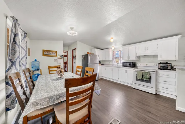 a kitchen with cabinets stainless steel appliances and wooden floor