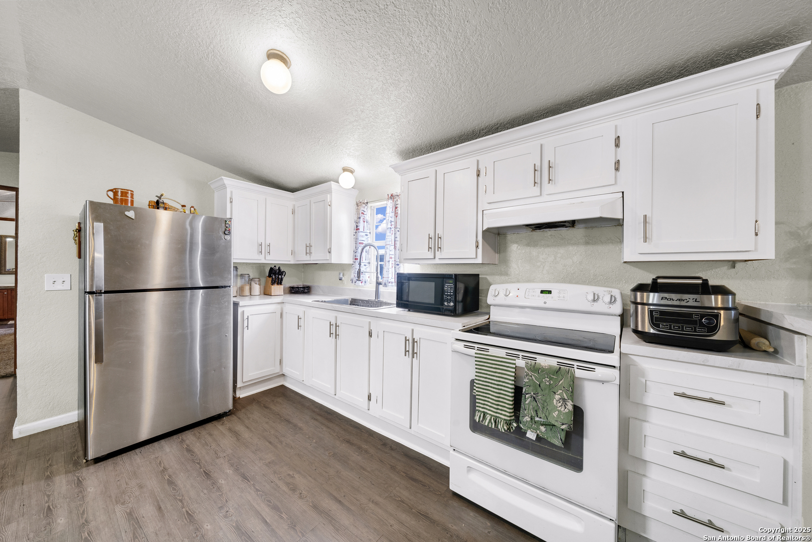 11791 Kinney Road Atascosa, TX 78002 - Photo 21 of 28 a kitchen with cabinets stainless steel appliances and wooden floor
