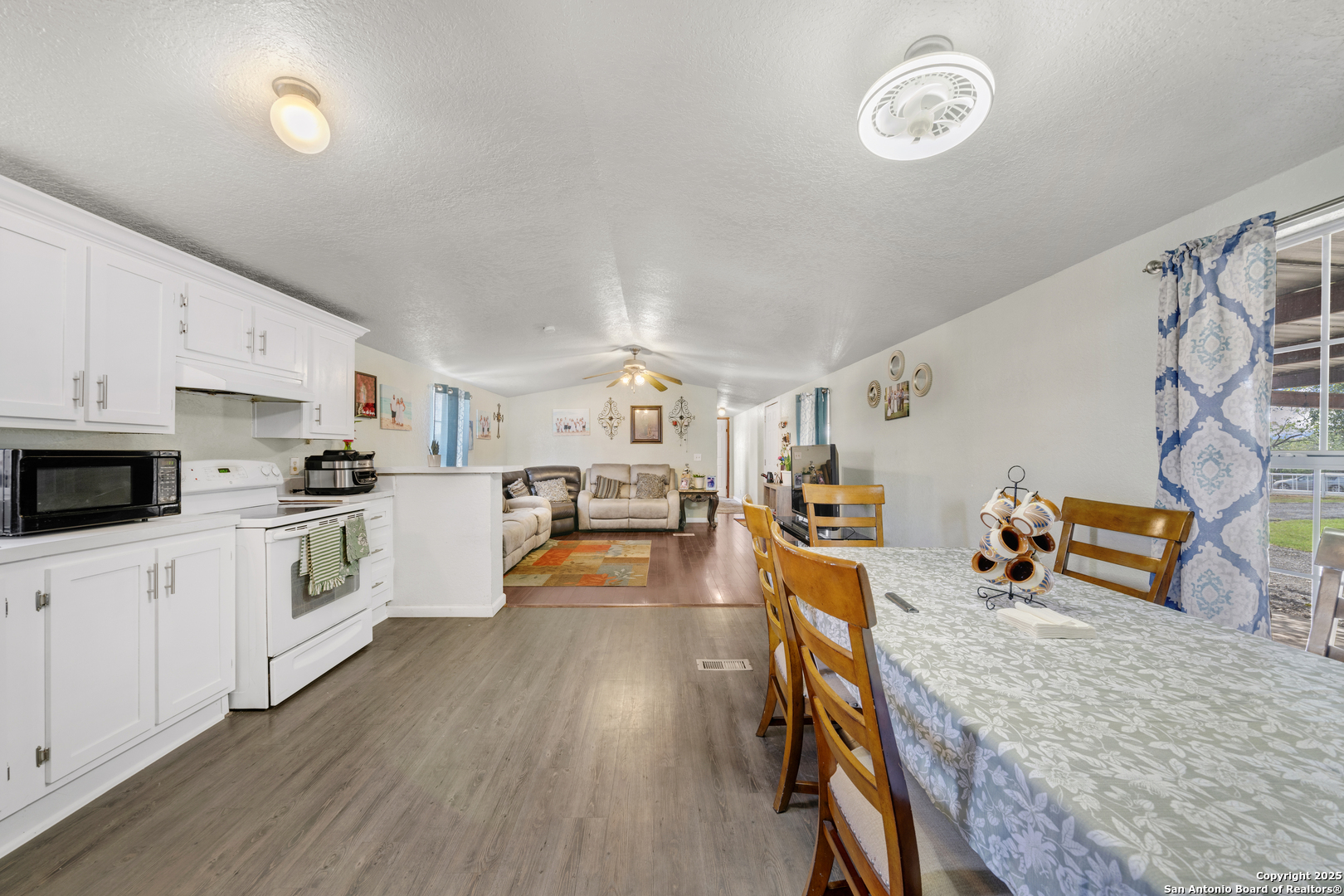 11791 Kinney Road Atascosa, TX 78002 - Photo 23 of 28 a kitchen with stainless steel appliances wooden floor and a refrigerator