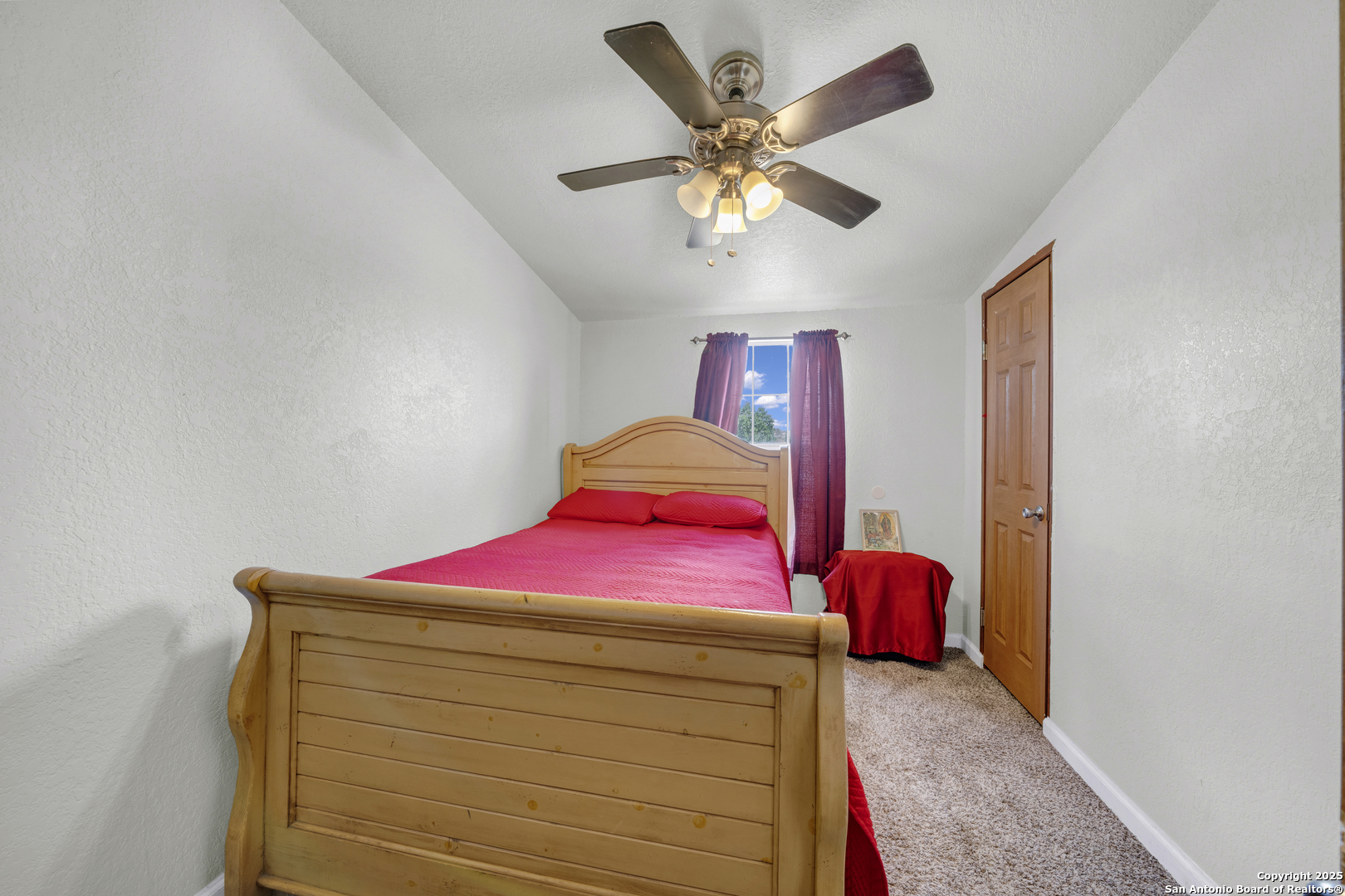 11791 Kinney Road Atascosa, TX 78002 - Photo 26 of 28 a bedroom with a bed and a chandelier