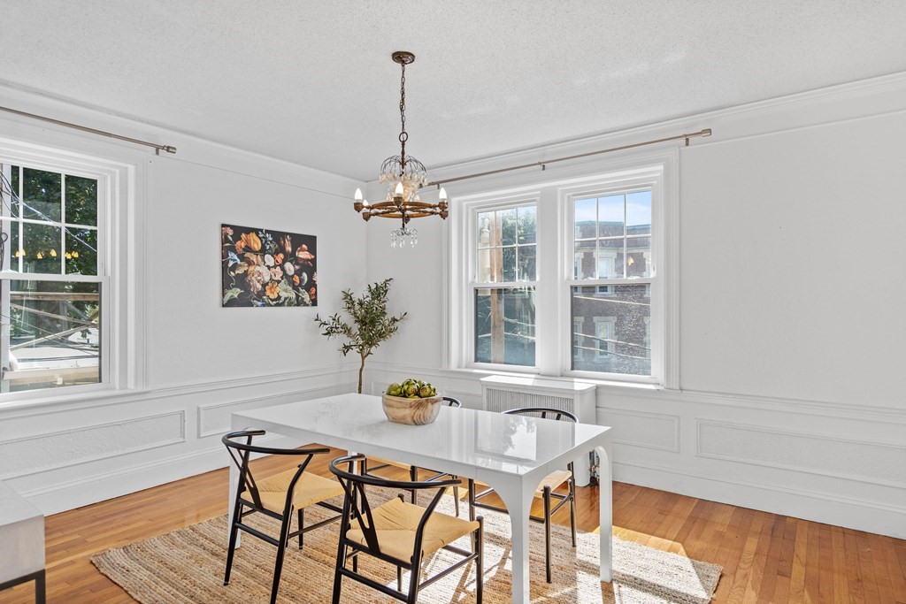 311 Tappan Street, Unit 2 Brookline, MA 02445 - Photo 12 of 26 a dining room with furniture a chandelier and wooden floor