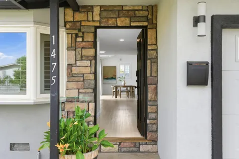 a view of a hallway with a dining table & chairs