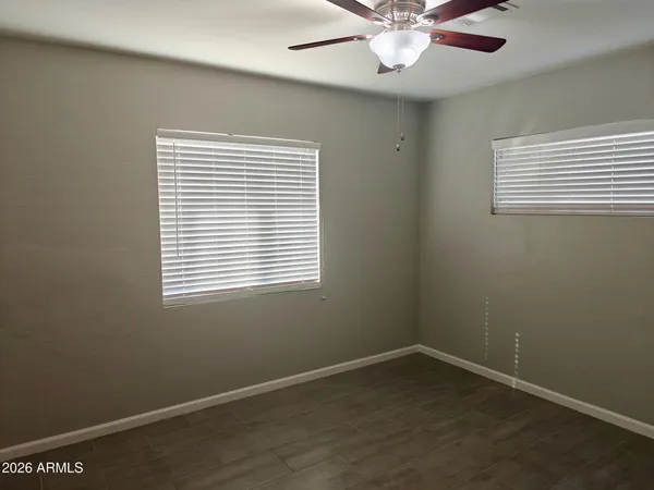 an empty room with a window and a fan