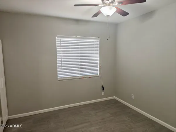 an empty room with a window and a fan