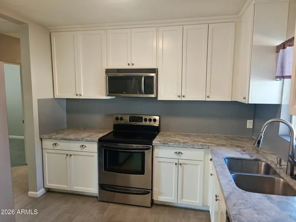 a kitchen with white cabinets and stainless steel appliances