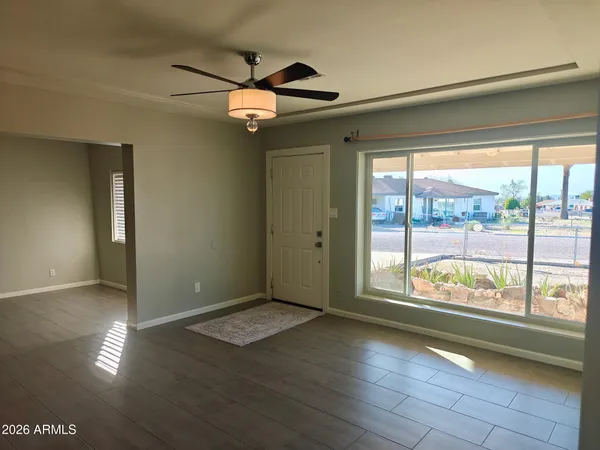 an empty room with wooden floor and windows