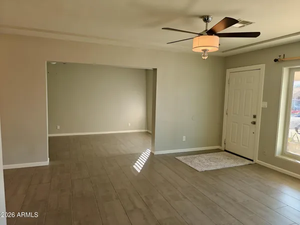 an empty room with wooden floor and windows
