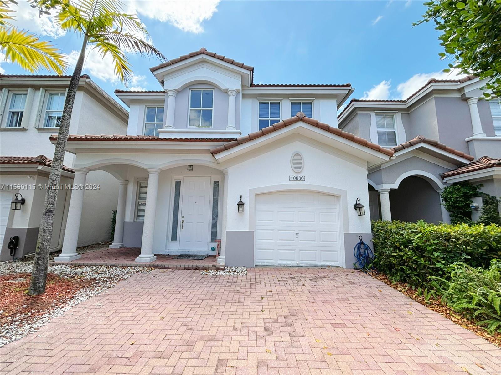 10860 Northwest 84th Street Doral, FL 33178 - Photo 1 of 19 a front view of a house with a yard and garage