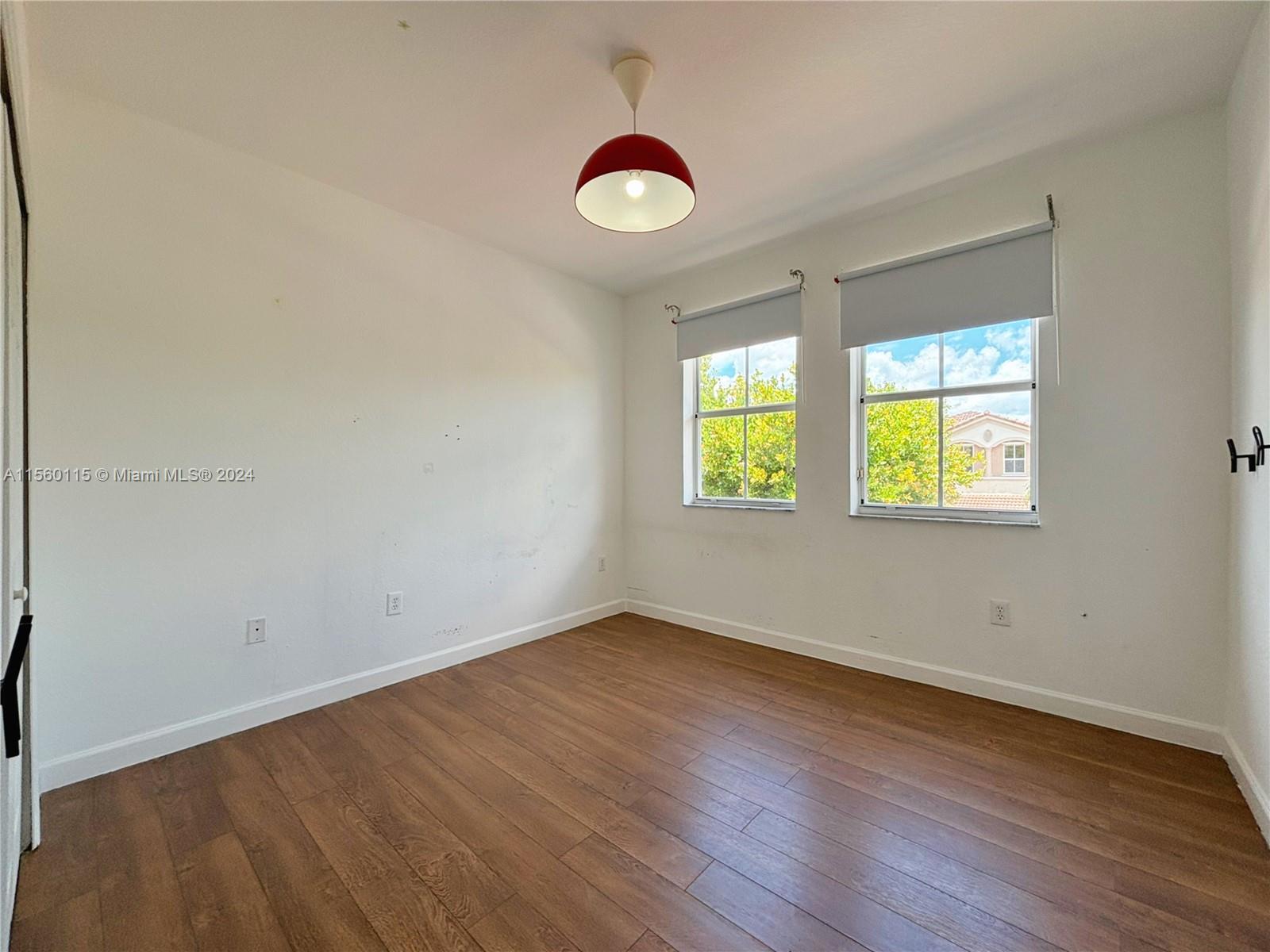 10860 Northwest 84th Street Doral, FL 33178 - Photo 15 of 19 an empty room with wooden floor and windows