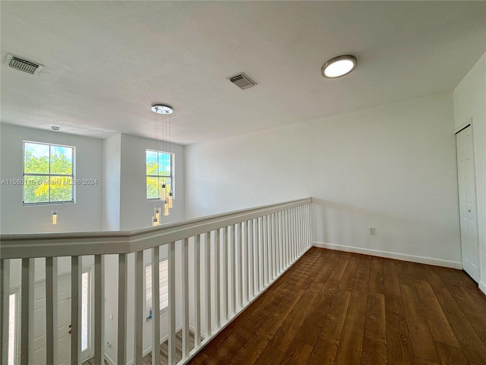 10860 Northwest 84th Street Doral, FL 33178 - Photo 16 of 19 a view of hallway with wooden floor and windows