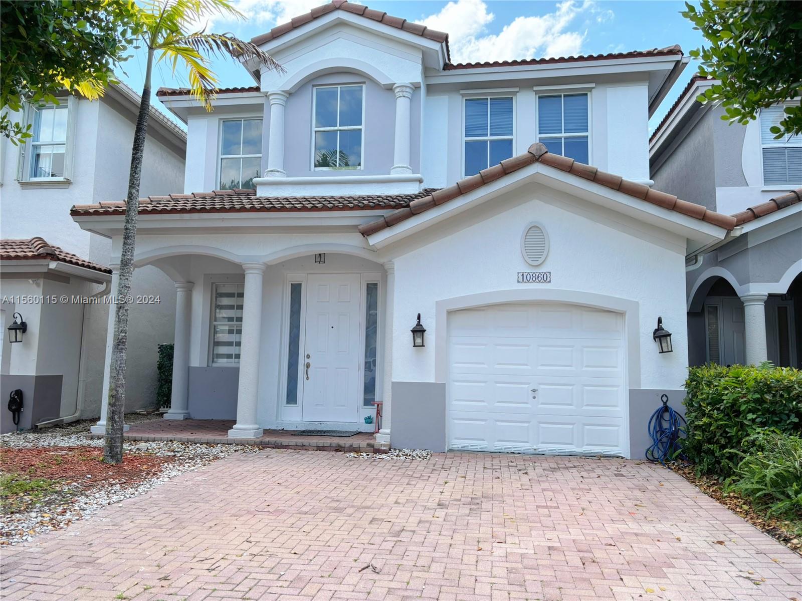10860 Northwest 84th Street Doral, FL 33178 - Photo 2 of 19 a front view of a house with a yard and garage