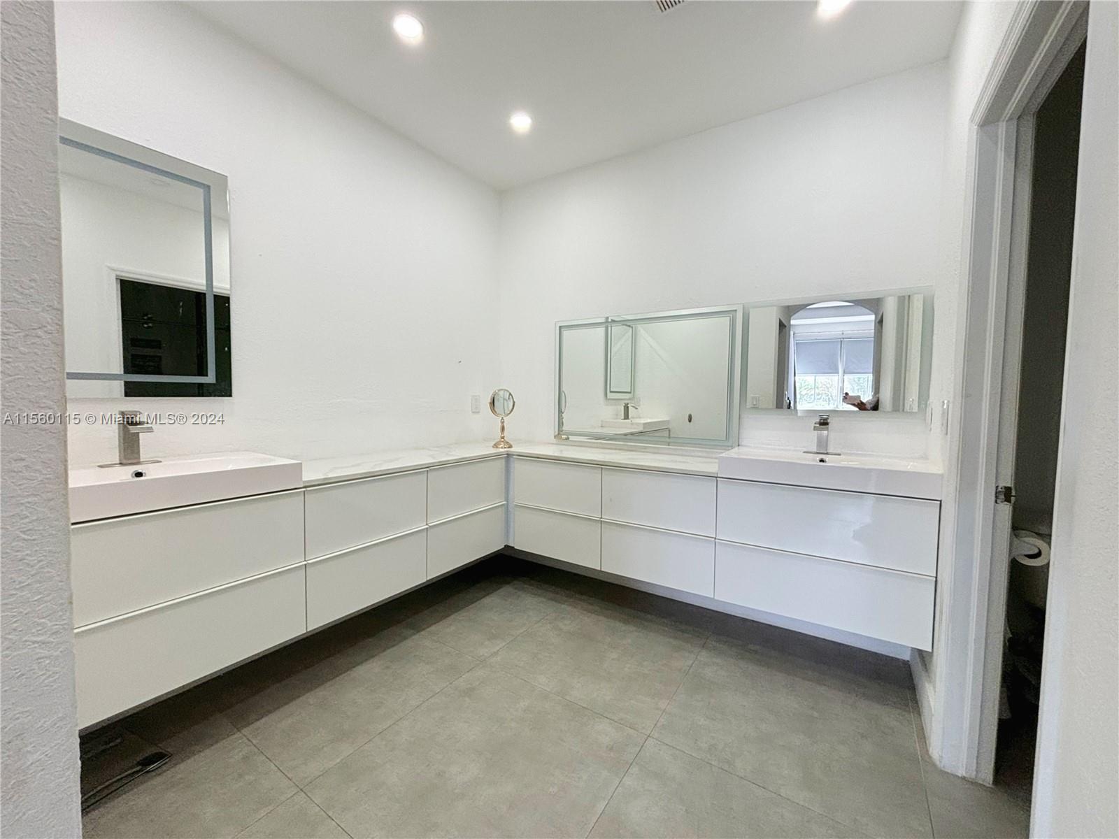 10860 Northwest 84th Street Doral, FL 33178 - Photo 3 of 19 a bathroom with a double vanity sink and mirror