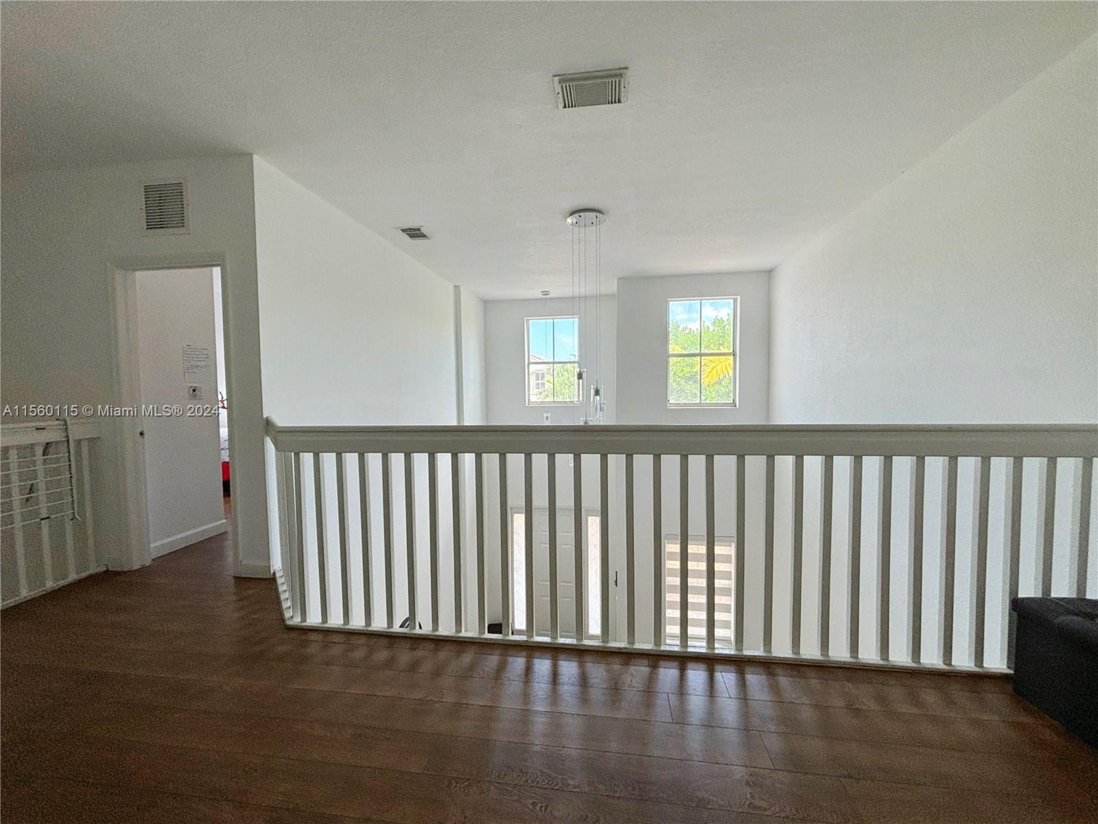 10860 Northwest 84th Street Doral, FL 33178 - Photo 5 of 19 a view of an empty room with wooden floor and a window