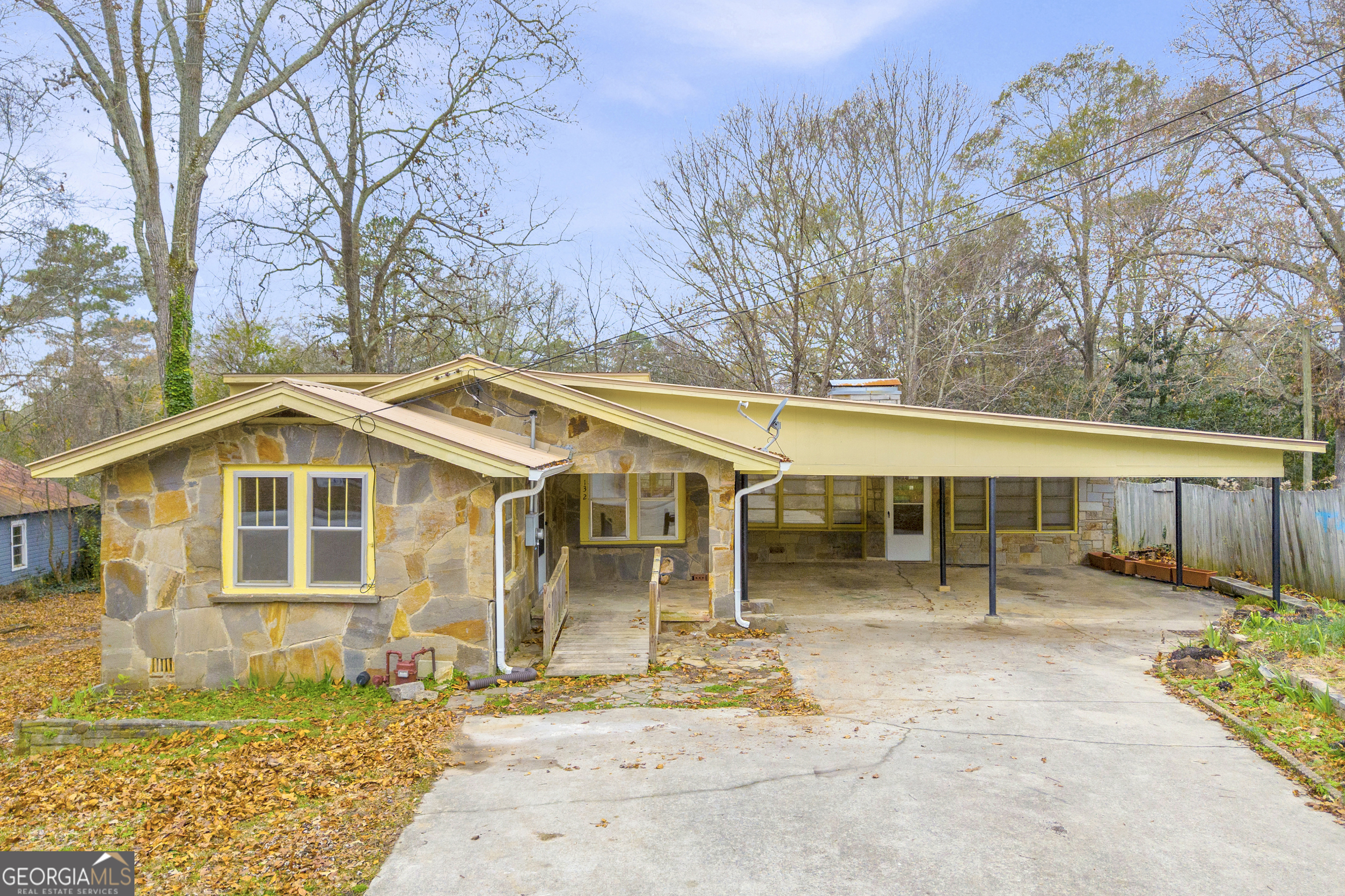 a view of a white house with a small yard and large tree