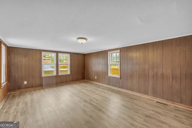 an empty room with windows and closet