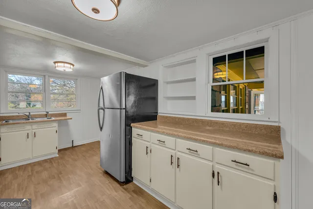 a kitchen with a refrigerator sink and cabinets
