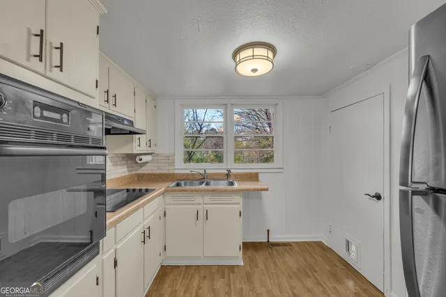 a kitchen with a sink window and cabinets