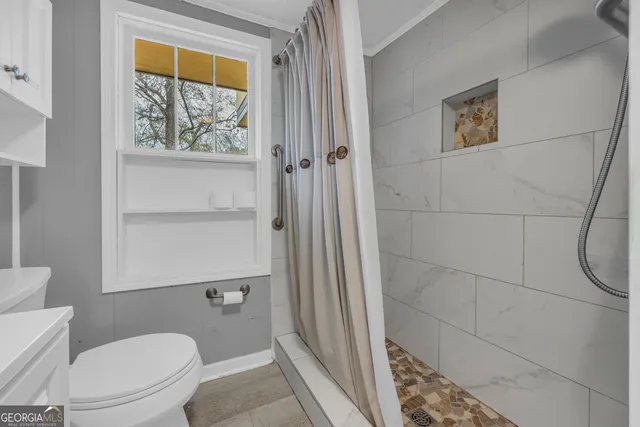 a white toilet sitting next to a shower