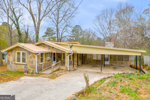 a front view of a house with a garden and trees