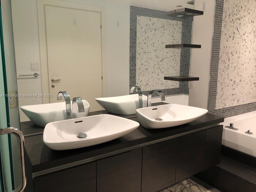 200 Biscayne Blvd Way, Unit 902 Miami, FL 33131 - Photo 14 of 23 a bathroom with a sink and a mirror