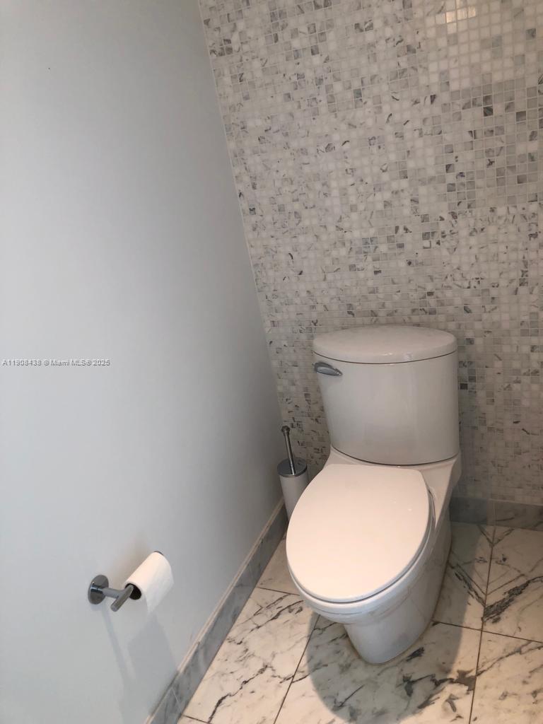 200 Biscayne Blvd Way, Unit 902 Miami, FL 33131 - Photo 16 of 23 a white toilet sitting next to a white wall