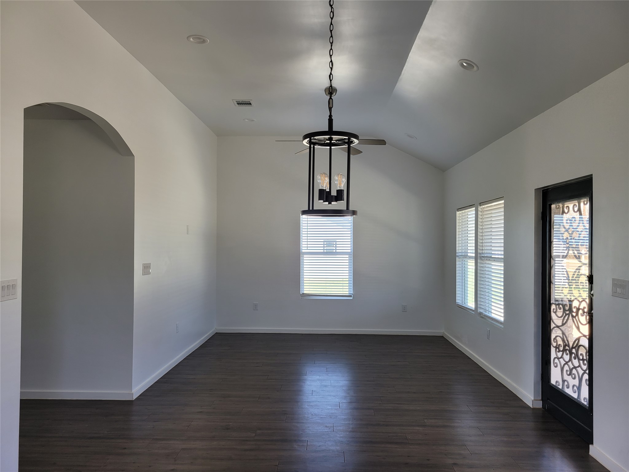 422 A Road Stockdale, TX 78160 - Photo 8 of 40 An open concept living area boasts vaulted ceilings and dark wood flooring, illuminated by natural light and recessed lighting.