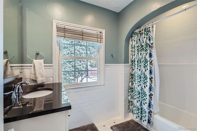a bathroom with a granite countertop sink a mirror a and a window