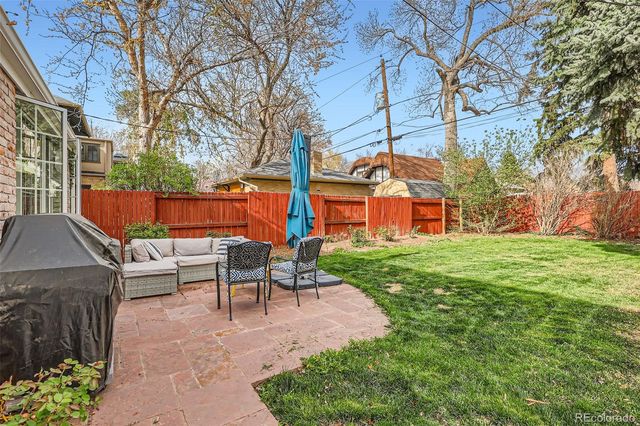 a view of backyard with table and chairs couches and a fire pit