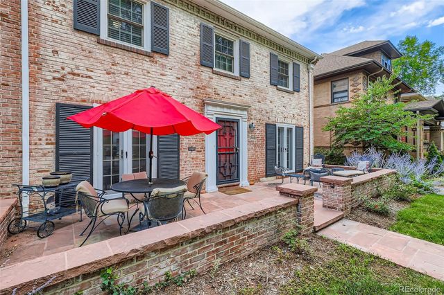 a view of a house with backyard sitting area and furniture