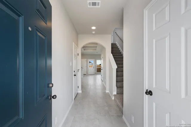 a view of a hallway with wooden floor and staircase