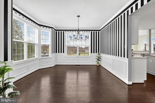 a kitchen with stainless steel appliances granite countertop a stove a sink dishwasher a dining table and chairs with wooden floor