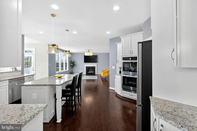 a view of a hallway with wooden floor and a living room
