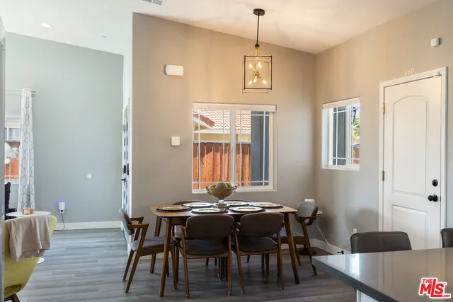 a kitchen with stainless steel appliances granite countertop a refrigerator a sink dishwasher a stove and white cabinets with wooden floor