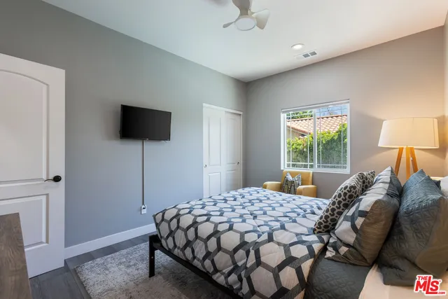 a bedroom with a bed and wooden floor