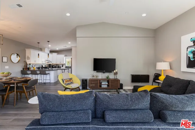 a living room with furniture kitchen view and a window