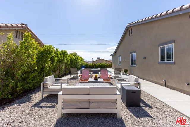 a view of a patio with a table and chairs under an umbrella