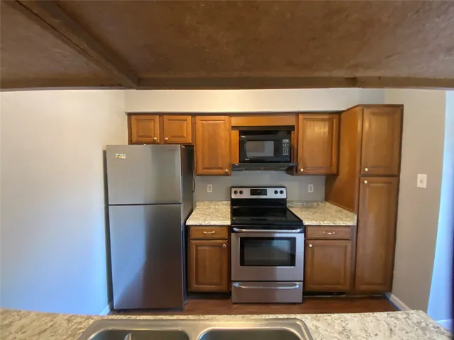 a kitchen with a refrigerator and a stove top oven