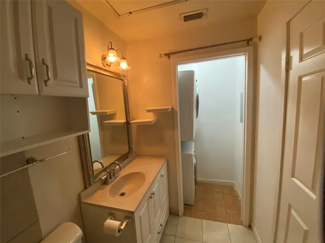 a bathroom with a sink mirror vanity and toilet