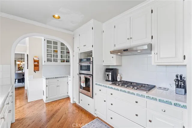 a kitchen with granite countertop white cabinets and white appliances