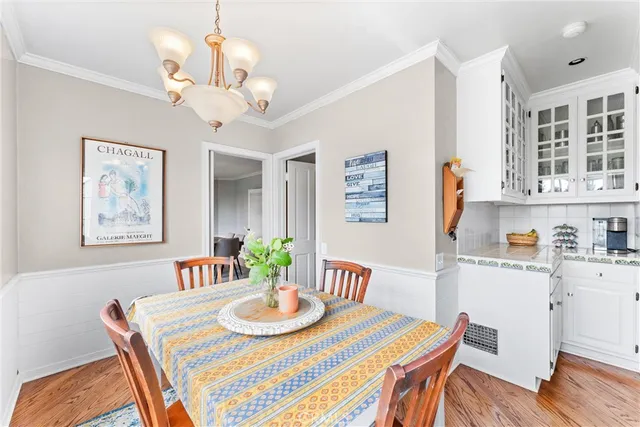 a view of a dining room with furniture a chandelier and wooden floor