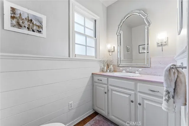 a view of a hallway with wooden floor and a living room