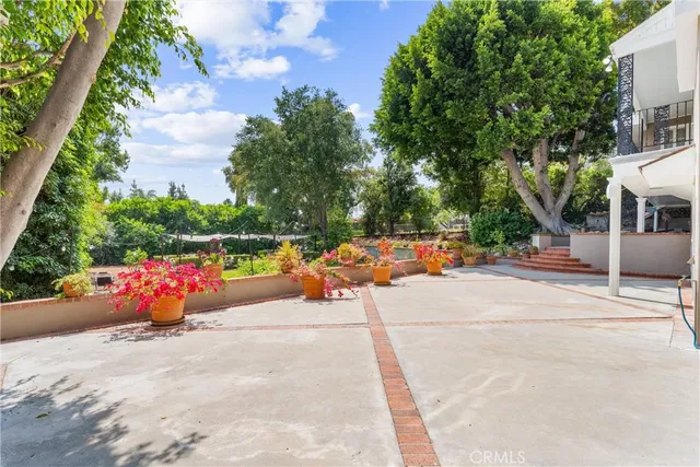 a view of a patio with couches table and chairs and potted plants