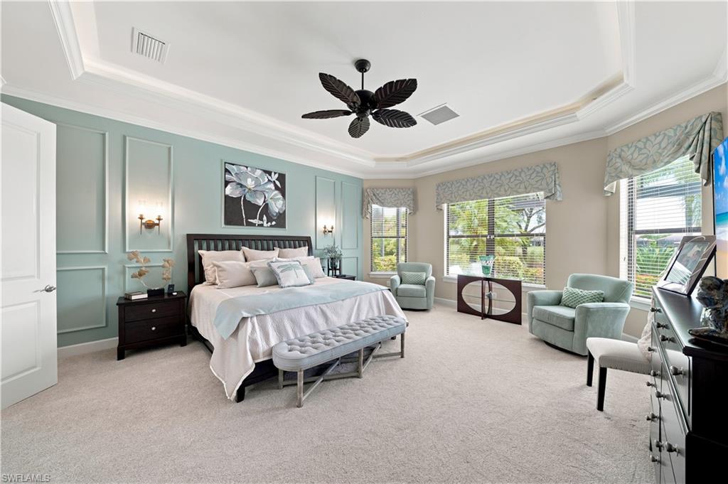 9256 Rialto Lane Naples, FL 34119 - Photo 23 of 43 Spacious room featuring tray ceilings with crown molding, light-toned wall paint, large windows with horizontal blinds, and light-colored carpeting