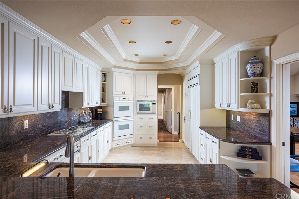 19051 Mesa Drive Villa Park, CA 92861 - Photo 21 of 28 a large kitchen with a stove a refrigerator a sink dishwasher and white cabinets with wooden floor